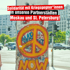 Foto des Mauerrestes am Potsdamer Platz auf dem ein Peace Zeichen abgebildet ist. Darüber steht „Solidarität mit Kriegsgegner*innen in unseren Partnerstädten Moskau und St. Petersburg“