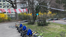Ein Foto der Fahrbahn der Jugendverrkehrsschule in der Bremer Straße. Es sind Tretautos und -Räder zu sehen und Wimpel und Ballons, die zum Saisonstart aufgehängt wurden. 
