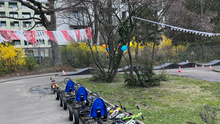 jvhs_bild Ein Foto der Fahrbahn der Jugendverrkehrsschule in der Bremer Straße. Es sind Tretautos und -Räder zu sehen und Wimpel und Ballons, die zum Saisonstart aufgehängt wurden.