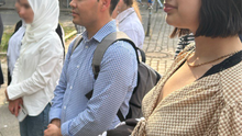 Foto der Bezirksverordneten Jacky Sanehy und Samiullah Haidary in einer Gruppe von Menschen bei der Kundgebung an der Friedensstatue in Berlin-Moabit.