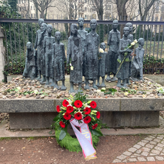 Foto des Denkmals am jüdischen Friedhof in der Großen Hamburger Straße. Im Gedenken sind dort Steine und ein Kranz niedergelegt.