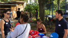 Foto des Stands der Linksfraktion Berlin Mitte beim Sommerfriedensfest. Im Bild sind Jonna Dickershoff, Samiullah Malekzadeh und Hannah Gerlof, die mit einer Besucherin des Festes spricht.