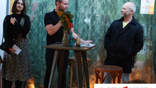 Foto der Redebühne im Außenbereich des Sommerempfangs der Linksfraktion Berlin-Mitte. Zu sehen sind Christoph Keller, Jacky Sanehy und Sven Diedrich die alle Reden zur Begrüßung hielten. Auf einem kleinen Tisch steht ein Blumenstrauß und Getränke. Unten Links ist das Logo der Fraktion DIE LINKE. in der BVV Berlin-Mitte eingefügt. 