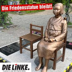 Ein Foto der Friedensstatue für die Trostfauen in Berlin-Moabit. Dort steht weiß auf rot: „Die Friedensstatue bleibt!“