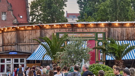 Eine Aufnahme der wartenden Menschen in der Schlange vorm Monbijoutheater vom Sommer 2022. Oben drüber steht „Monbijoutheater, Humboldthain-Club, Jugendkulturzentrum Pumpe: Wir setzen uns für Kultur für alle in Mitte ein“