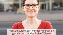 Foto der Bezirksverordneten Hannah Gerlof. Sie steht auf der Karl-Marx-Alle mit verschränkten Armen. In einer Textbox steht ein direktes Zitat „Nicht zu kürzen darf nur der Anfang sein – gemeinsam mit den freien Trägern unterstützen wir die Forderung für den Erhalt und den Ausbau der Jugendsozialarbeit in Mitte!“