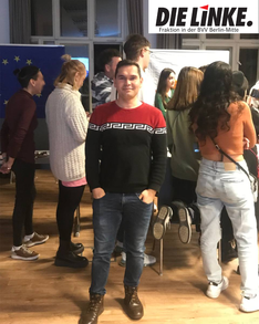 sami_wasla Ein Foto des Bezirksverordneten Samiullah Haidary vor einer Gruppe junger Menschen bei einer Veranstaltung. Im Hintergrund ist eine EU-Fahne zu sehen.