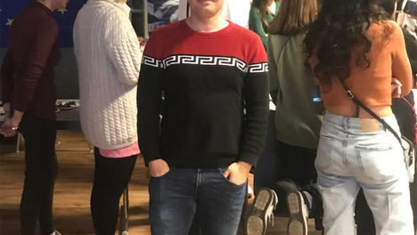 sami_wasla Ein Foto des Bezirksverordneten Samiullah Haidary vor einer Gruppe junger Menschen bei einer Veranstaltung. Im Hintergrund ist eine EU-Fahne zu sehen.